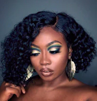 a black woman with green eye makeup and curly hair